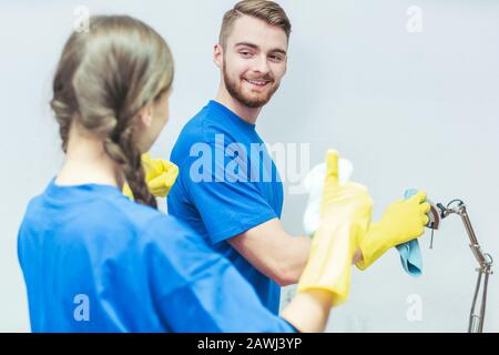 Pulizia della squadra spolverare un ufficio Foto Stock
