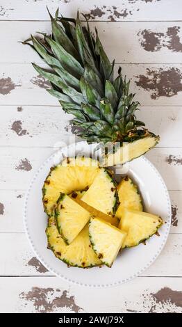 ananas fresco tagliato sul vecchio legno bianco dipinto Foto Stock