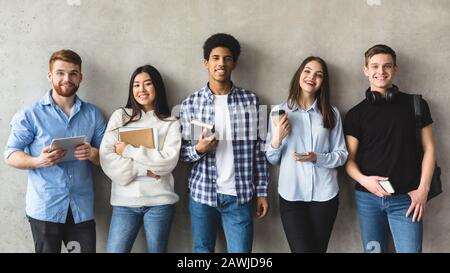 Gruppo multietnico di studenti universitari contro il muro del college Foto Stock