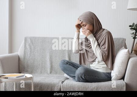 Ragazza Musulmana Ammalata Che Soffre Di Temperatura E Naso Runny A Casa Foto Stock