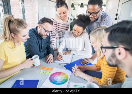 I giovani uomini di affari riunione in ufficio e discutendo insieme un nuovo progetto di avvio. Foto Stock
