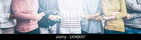 Il team creativo incontra le mani in linea. I giovani imprenditori stanno tenendo le mani. Concetto di unità e lavoro di squadra. Foto Stock