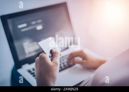 Mani che tengono la carta di credito e che usano il portatile. Pagamento online e concetti di shopping. Foto Stock