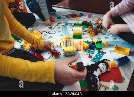 I bambini che giocano con i giocattoli dei blocchi da costruzione su un tappetino da gioco Foto Stock