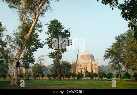 La tomba di Sikander Lodi all'alba, in una mattinata estiva circondata da alberi e grandi formazioni rocciose sotto il cast ky a Delhi, Uttar Pradesh, India. Foto Stock