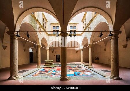 Italia Toscana Volterra - Chiostro di Palazzo Solaini, oggi sede della galleria d'arte civica e dell'eco-museo alabastro. Al centro del cortile si trova un'installazione temporanea relativa all'esposizione del Rosso Fiorentino. Foto Stock