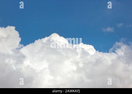 Grandi e soffici nuvole bianche su uno sfondo blu chiaro e luminoso Foto Stock