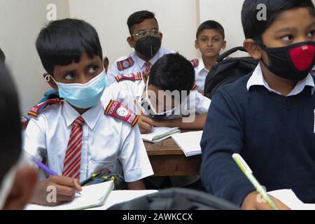 Covid 190 Feb 2020 i bambini della scuola di Cambridge a Dhaka hanno visto indossare una maschera per proteggersi dalla minaccia di Coronavirus. Tuttavia, nessuno si confidi Foto Stock