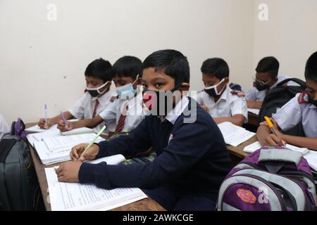 Covid 190 Feb 2020 i bambini della scuola di Cambridge a Dhaka hanno visto indossare una maschera per proteggersi dalla minaccia di Coronavirus. Tuttavia, nessuno si confidi Foto Stock