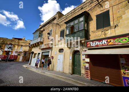 Victoria, Gozo - 8th ottobre 2018: Turisti che camminano lungo il marciapiede di Victoria Foto Stock