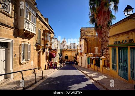 Victoria, Gozo - 8th ottobre 2018: Turisti che camminano lungo il marciapiede di Victoria Foto Stock