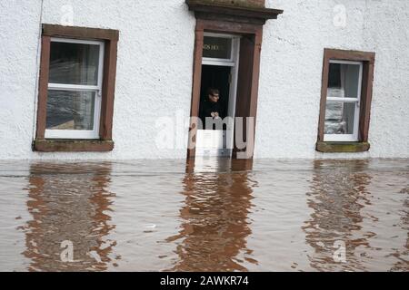 Una donna guarda sulle strade allagate di Appleby-in-Westmorland, Cumbria, come Storm Ciara colpisce il Regno Unito. Foto Stock