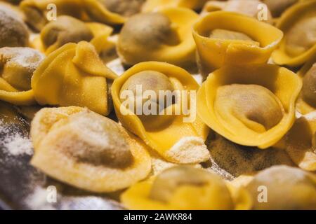 Primo piano di pasta fresca tortellini ricoperti di parmigiano grattugiato Foto Stock