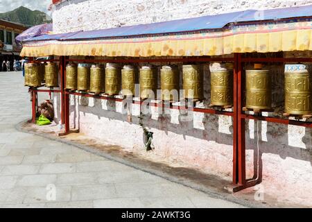 Vista sulle ruote di preghiera di colore dorato. Secondo la tradizione buddista tibetana la ruota ha lo stesso effetto di recitare il mantra. Foto Stock