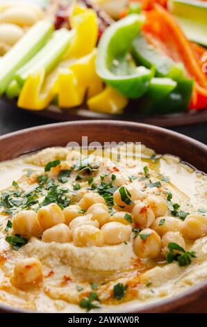 Vista a basso angolo su piatto di verdure con hummus condito con ceci e olio d'oliva Foto Stock