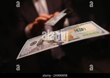 Uomo in business suit figliata denaro, dollari di primo piano Foto Stock