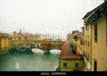 Ponte Vecchio - defocused view attraverso la finestra coperta in pioggia, focus sulle gocce di pioggia, Firenze, Italia Foto Stock