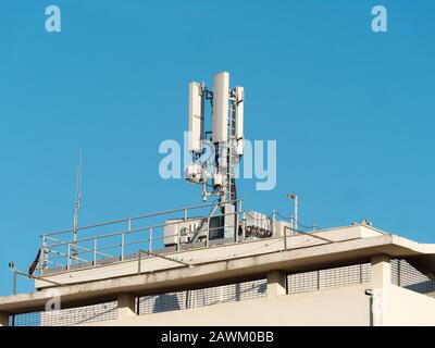 Antenna comunicazione mobile sulla parte superiore di un edificio Foto Stock