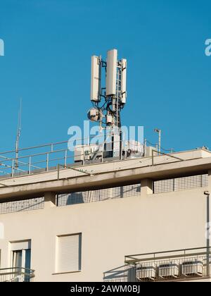 Antenna comunicazione mobile sulla parte superiore di un edificio Foto Stock