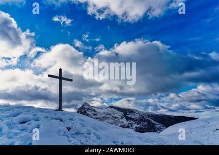 croce di legno in montagna con neve Foto Stock
