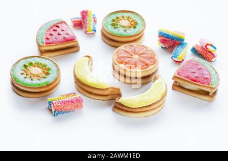 Diversi tipi di biscotti frollini dolci con gelatina di frutta su sfondo bianco Foto Stock