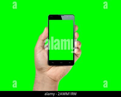 Tenere la mano in primo piano e mostrare lo smartphone o il cellulare con lo schermo verde isolato sul verde. Foto Stock