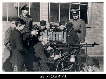 Vintage WW2 1940 i funzionari tedeschi di Wehrmacht insegnano e addestrano i ragazzi tedeschi della Gioventù Hitler, l'Hitlerjugend, il movimento giovanile del Partito nazista, come far funzionare una mitragliatrice MG-34 per consentire ai suoi membri di combattere fedelmente per la Germania nazista come soldati.1942. Seconda guerra mondiale Foto Stock