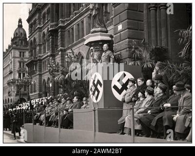 D'epoca anni '30 VIENNA ANSCHLUSS PROPAGANDA 1938 Rally nazista a Vienna con il leader del servizio civile del Reich Hermann Neef al lleggio nazista di Swastika, con alti funzionari viennesi e leader politici seduti. Adolf-Hitler-Platz (Vienna Rathausplatz). 1938 Vienna Austria Nel corso dei numerosi eventi nazionalsocialisti di propaganda per il referendum per il 'Anschluss' del 1938-04-10 il capo della funzione pubblica del Reich Hermann Neef ha parlato davanti ai funzionari austriaci al Rathausplatz di Vienna. Nel suo discorso, Neef orates ai funzionari sui principi della 'comunità tedesca' Foto Stock