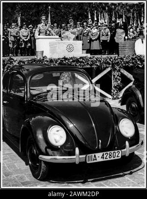 ADOLF HITLER parla negli anni '30 al lancio di KDF-Wagen VOLKSWAGEN. Hitler sta facendo un discorso dietro la pietra di fondazione scolpita nazista swastika al lancio della "People's car" KDF-Wagen VW Volkswagen Beetle vettura raffreddata ad aria, un acclamato e ispirato design dal genio automobilistico Dr Porsche, lanciato a Fallersleben Wolfsburg Germania maggio 1938 Foto Stock