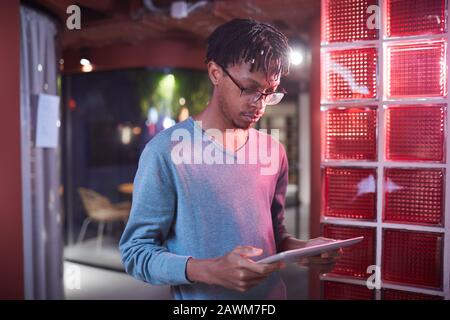 Ritratto in vita di uomo contemporaneo afro-americano utilizzando tablet digitale mentre si lavora in ufficio futuristico interni, copia spazio Foto Stock