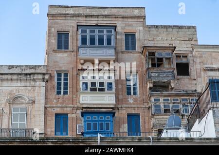 Valletta, Malta - 5 gennaio 2020: Tende e balconi tipici maltesi in condizioni decadenti Foto Stock