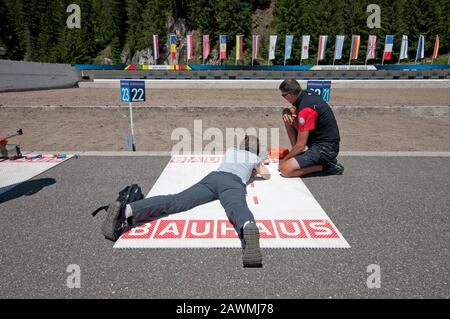 Istruttore che insegna ai visitatori a sparare con il fucile da biathlon nel Centro Biathlon Anterselva, Valle Anterselva (Anterolzertal), Trentino Alto Adige Foto Stock