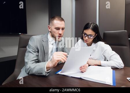 Responsabile seduto alla scrivania, segretario che porta il contratto a firmare Foto Stock
