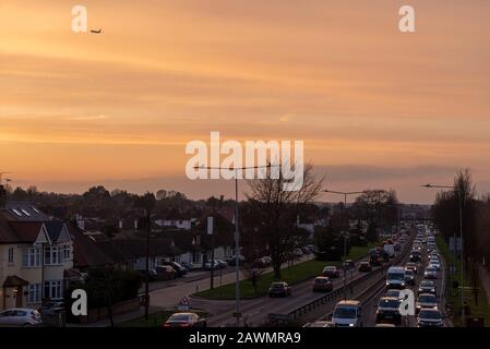 Un Ryanair Boeng 737 che sale fuori dall'aeroporto di Southend di Londra su traffico di ora di punta sulla A127 a Southend sul mare, Essex, Regno Unito. Tramonto Foto Stock