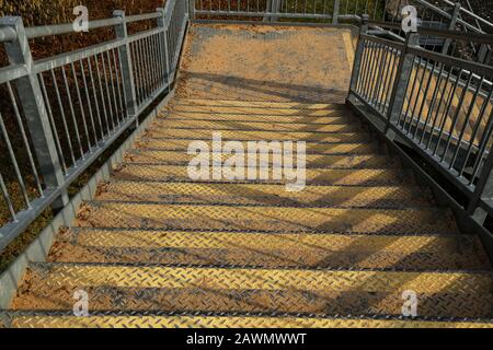Scale in metallo con gradini cosparsi di sabbia Foto Stock