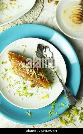 Concetto di dolce turco. Triangoli di baklava, dolce tradizionale turco dolce con pasta fillo, noci e miele. Sfondo bianco. Foto Stock