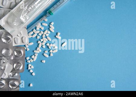 Blister vuoti usati da compresse color argento e bianco e pillole si trovano su sfondo medico blu. Concetto farmaceutico Salute cura e medicina. Fre Foto Stock