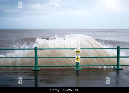 Segnali di allarme e onde che si infrangono sulle difese del mare durante la tempesta Ciara a Seaburn, Sunderland, Inghilterra, Regno Unito, 09 Feb 2020 Foto Stock