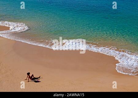 Donna di razza mista sdraiata a Big Beach, Makena state Park, Maui, Hawaii. Foto Stock