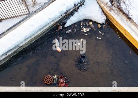 L'acqua raccolta su un tetto visto da un ponte sopra contiene rifiuti che sono stati gettati via. Foto Stock