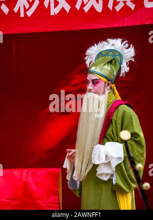 Uomo che esegue l'opera all'aperto di Pechino in costumi colorati, quartiere Xi Cheng Hutong, Pechino, Cina Foto Stock