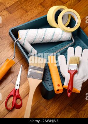 Strumenti essenziali per la verniciatura: Rulli e vassoio per la verniciatura, spazzola, nastro adesivo, guanti, forbici Foto Stock