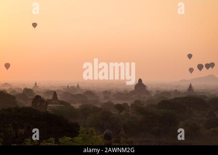 Bella vista di palloncini d'aria calda sopra templi e pagode all'antica pianura di Bagan in Myanmar (Birmania) all'alba. Spazio di copia. Foto Stock