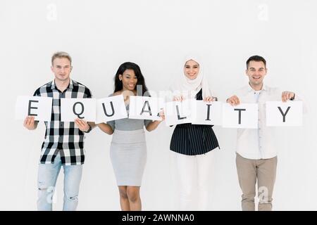 Parità Di Razze, nessun concetto di razzismo. Gare unite contro la discriminazione e il razzismo. Quattro persone multietniche che tengono insieme i fogli di carta con Foto Stock