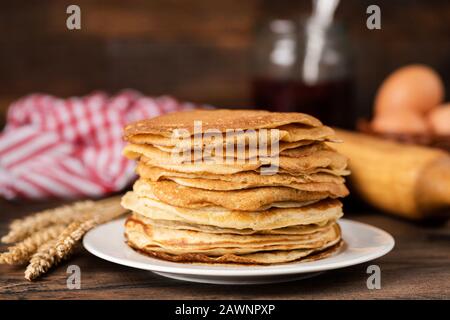 Blini, blintzes, crepes russo stacked on plate su sfondo rustico composizione. Concetto di tradizionale festa nazionale Maslenitsa Foto Stock