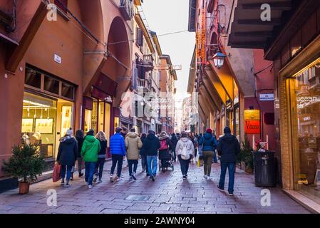 Bologna, Italia - Dicembre 2019 Persone che camminano in Via d'Azeglio, una famosa strada piena di negozi di alto livello nel caratteristico centro medievale della città di B. Foto Stock