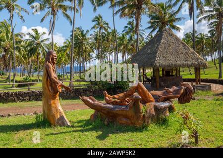 Statue di legno presso la spiaggia di Anakena, circondata da palme tropicali, nel Parco Nazionale Rapa Nui, sulla costa settentrionale dell'Isola di Pasqua (Rapa Nui), Cile Foto Stock