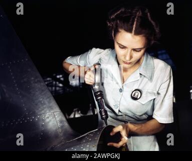 La signora Virginia Davis, Riveter in Assembly and Repair Department, si è arrangiata per la cura dei suoi due figli durante il giorno e si è unita al marito al lavoro nella base aerea navale, Corpus Christi, Texas, USA, fotografia di Howard R. Hollem, U.S. Office of War Information, agosto 1942 Foto Stock