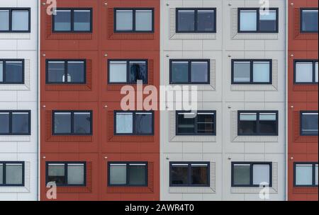 Ampio shot di appartamenti bianchi e rossi con finestre su ogni livello Foto Stock