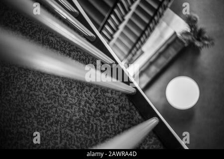 Immagine in scala di grigi di ringhiere all'interno di un edificio con un sfondo sfocato Foto Stock